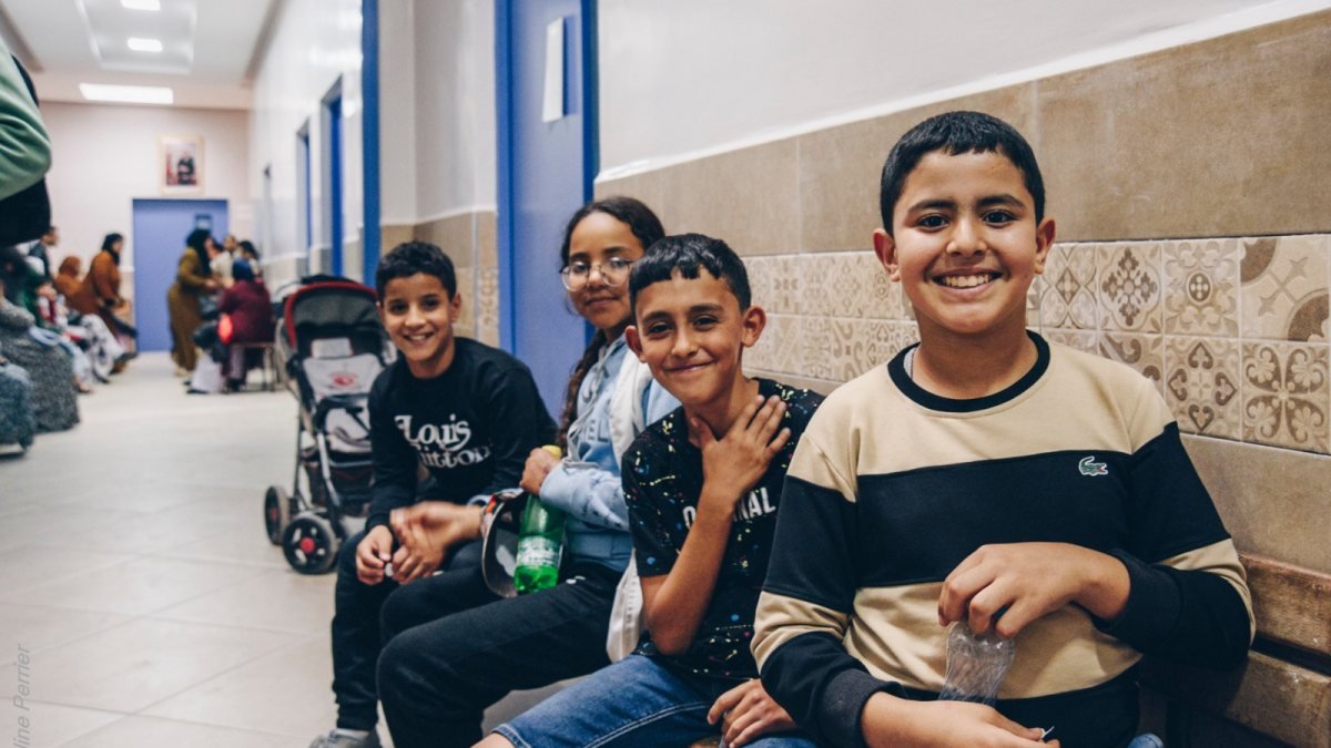 Des enfants attendent leur consultation dans le couloir d’un centre de soins.